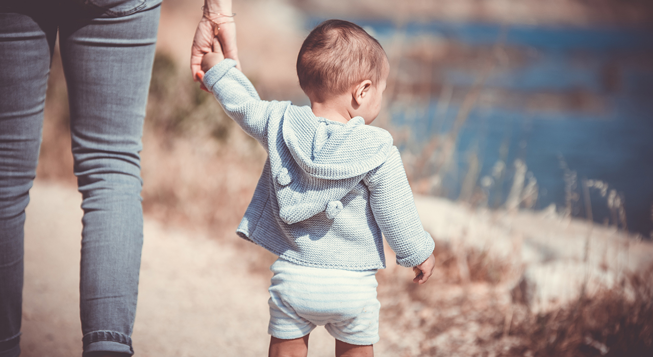 お母さんに手を繋いで散歩する子供
